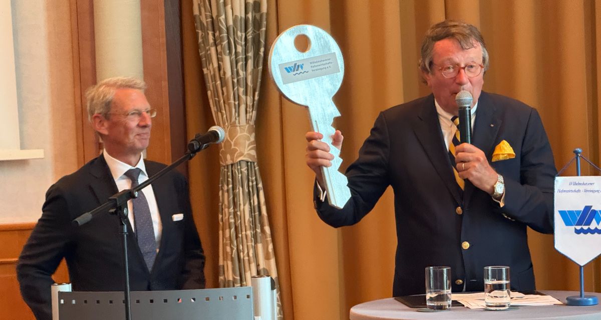 Zwei Männer bei einer Schlüsselübergabe anlässlich eines Empfangs