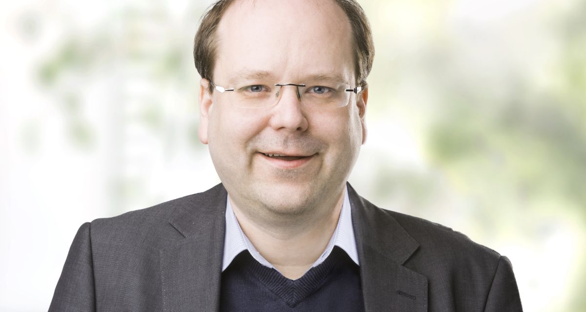 Ein Mann lächelt in die Kamera.