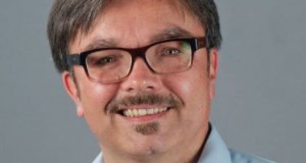 Zu sehen ist ein Mann. Er trägt Brille und hat einen Bart.