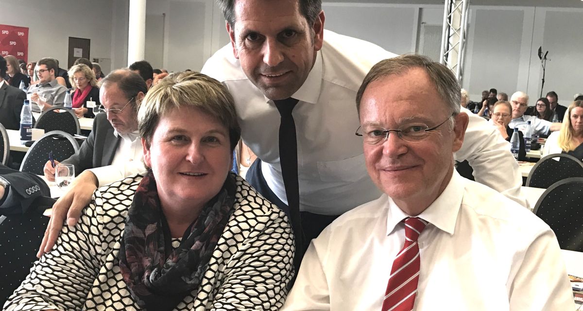 Zwei Männer und eine Frau posieren für die Kamera