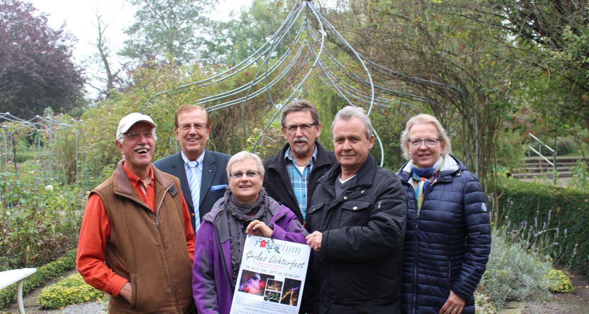 Lachende Menschen stellen das Lichterfest am Rosarium  vor. 
