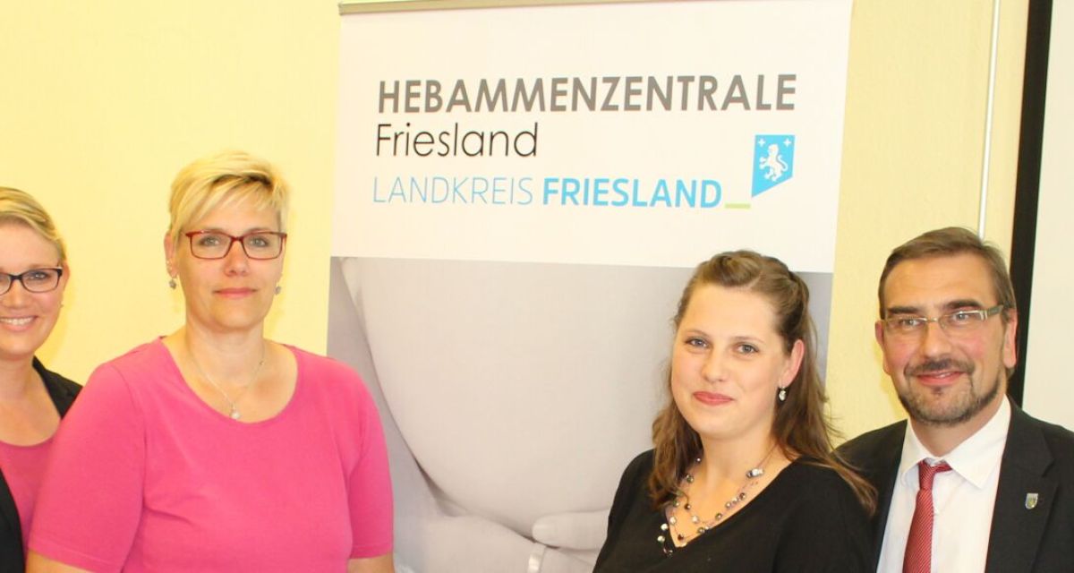 hebammen und Funktionare vor Schild