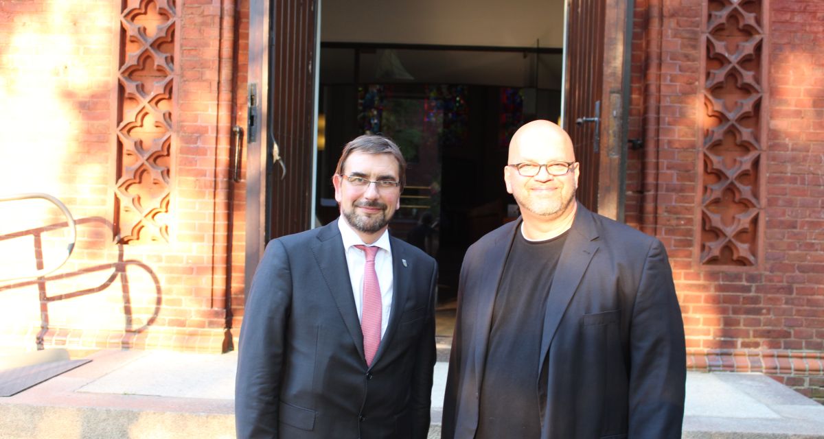 Sven Ambrosy und Bruder Franziskus vor dem Eingang der Christus- und Garnisonkirche in Wilhelmshaven.