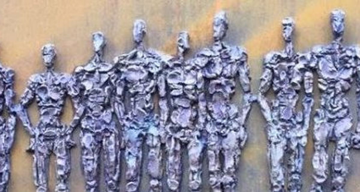 Zu sehen ist das Revolutionsdenkmal: silber-graue Männer auf Stein. 