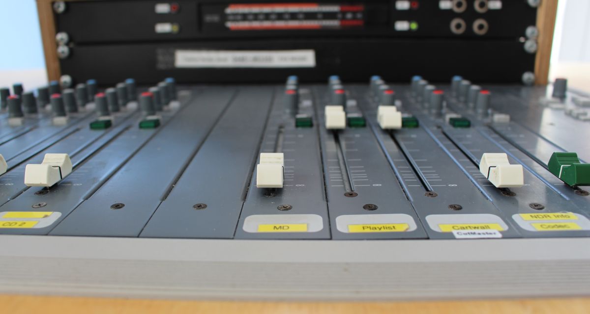 Zu sehen ist ein Mischpult mit unterschiedlich eingestellten Schiebereglern.