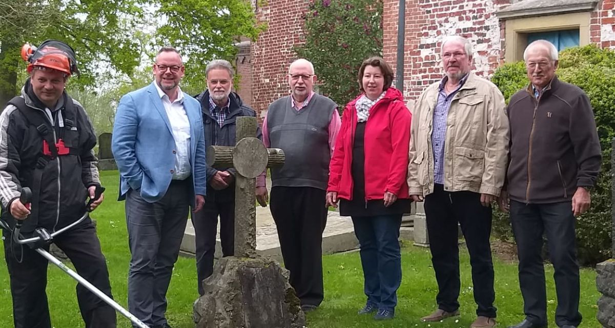 Auf dem Bild sind Vertreter der evangelischen Kirchengemeinden Fedderwarden, Sengwarden, Heppens und Neuende auf einem Friedhof zu sehen. 