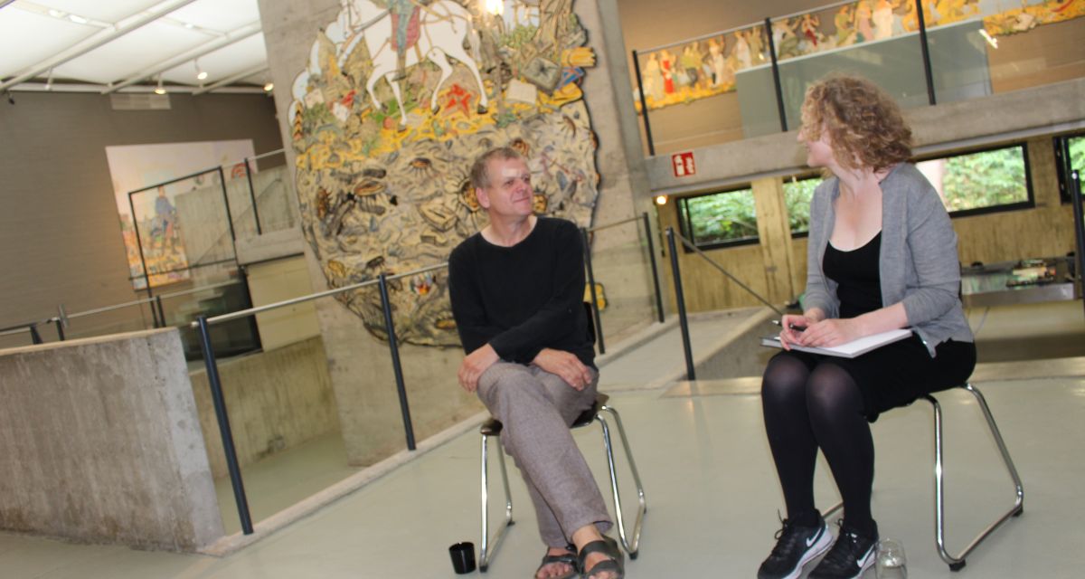 Der Künstler Moritz Götze sitzt mit Kunsthallenleiterin Petra Stegmann  vor einem seiner Werke