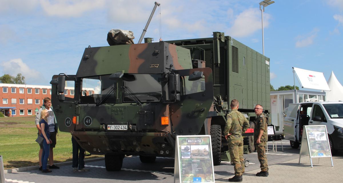 Vertreter des Landkreises Friesland stehen auf der K311 und zeigen auf die Straßenschäden.