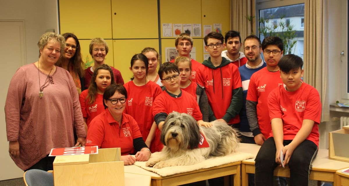 Hund auf Tisch mit Menschen dahinter