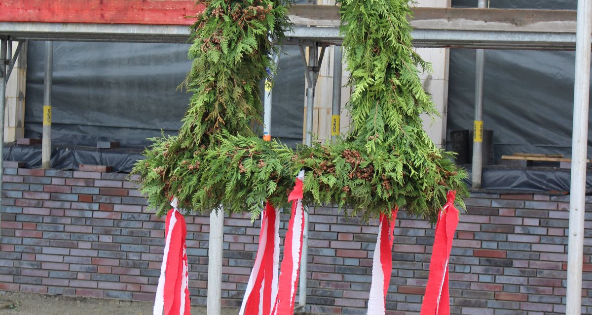 Zu sehen ist eine traditionelle Richtkrone mit Tannengrün und rot-weißen Bändern. 