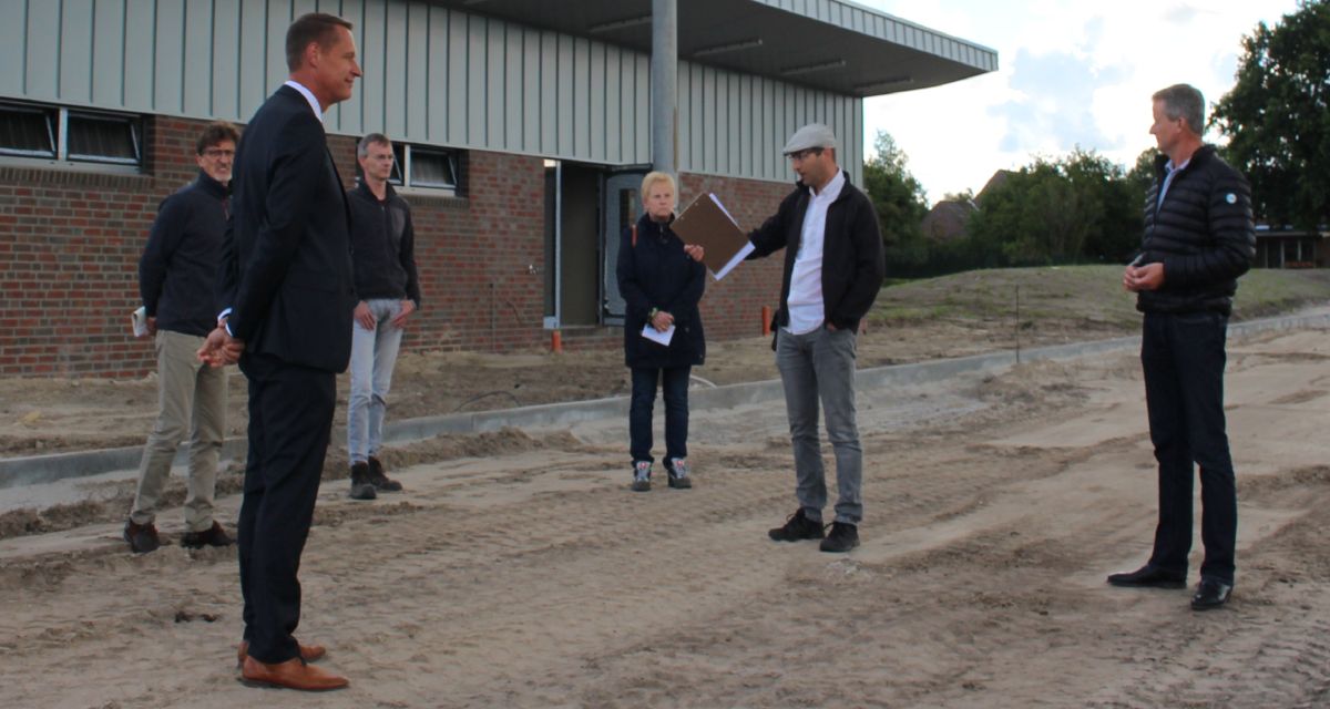 Sechs Männer und eine Frau stehen auf einer Baustelle des Stadions Wittmund. Landrat Holger Heymann ist ebenfalls dabei.