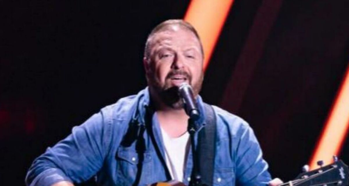 Mann in Jeanshemd mit Gitarre