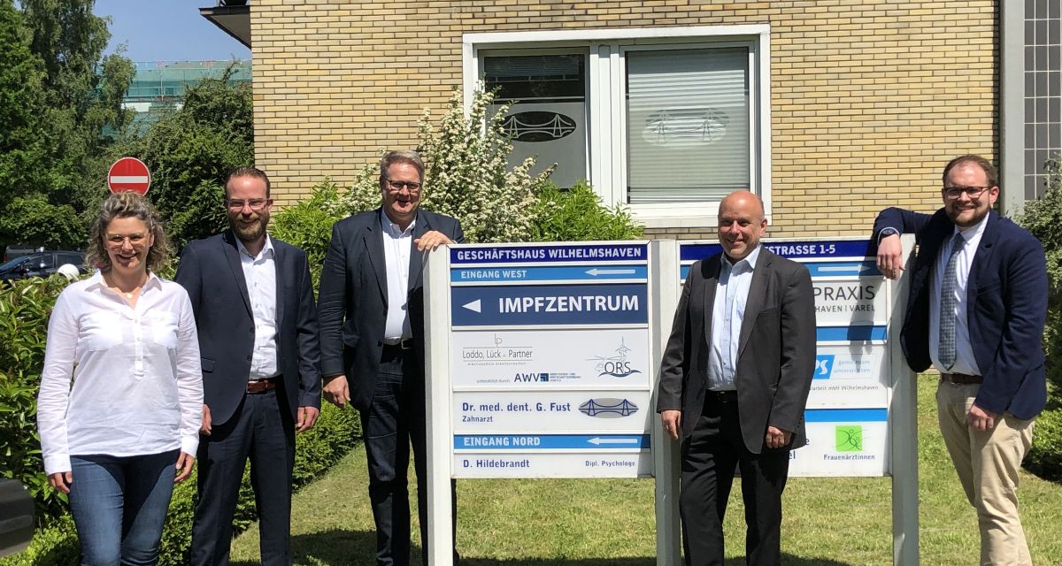 Der Arbeitgeber- und Wirtschaftsverband Jade (AWV) stellt sein Impfzentrum in der Marktstraße in Wilhelmshaven vor. Zu sehen sind unter anderem Tom Nietiedt, Henning Wessels, Daniel Löwe und Thomas Getrost vor dem Hinweisschild zum Zentrum