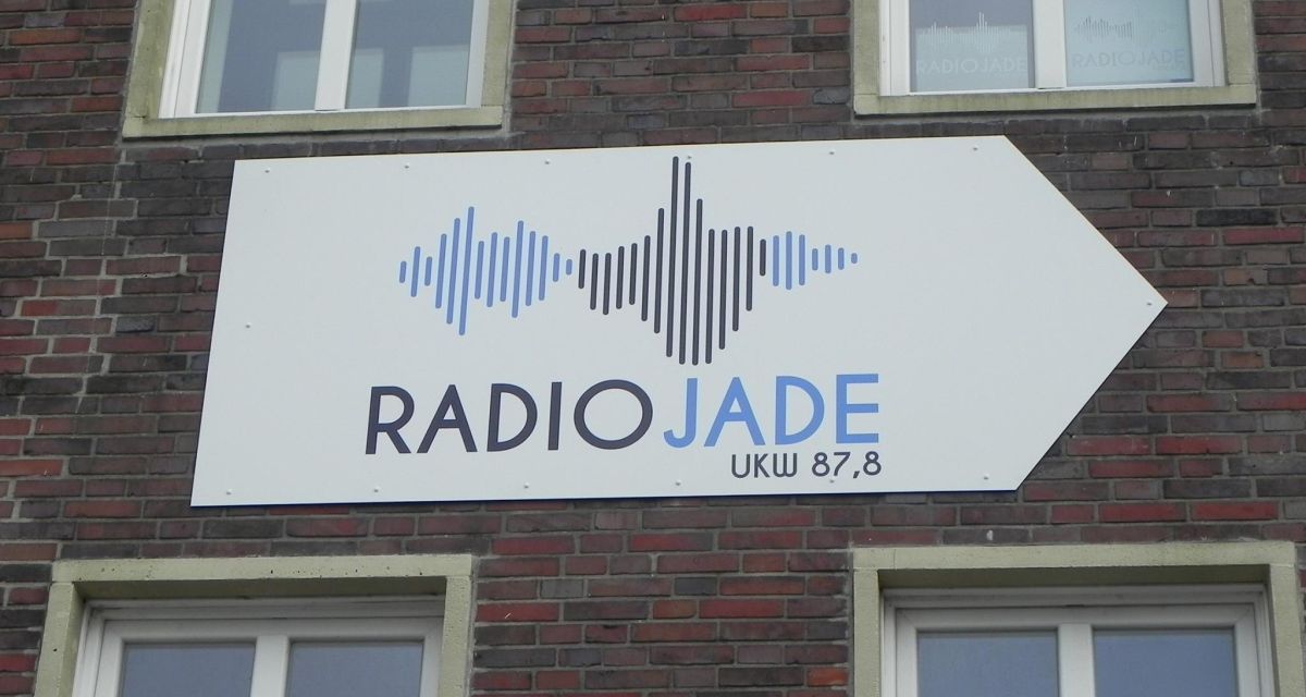 Zu sehen ist das Radio Jade Logo an einer Hauswand.