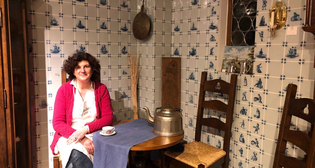 Eine Frau sitzt in einer altertümlichen Friesischen Teestube.