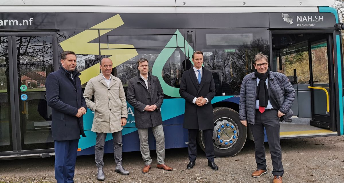 Die Unterstützer und Organisatoren des ersten Wasserstoffsbuss in Friesland stehen vor dem Fahrzeug