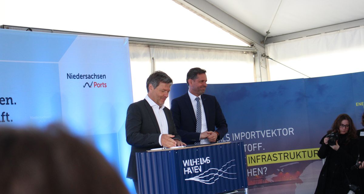 Robert Habeck und Olaf Lies stehen auf einem Podium in einem Zelt. 