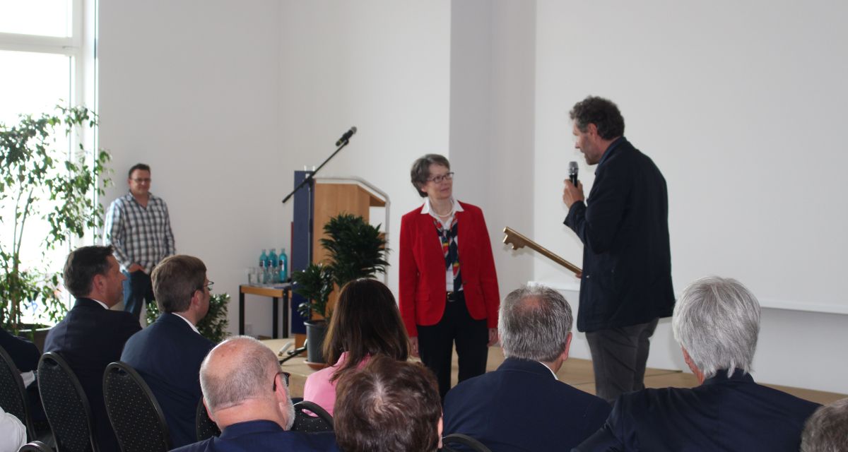 Offizieller Festakt zur Wiedereröffnung des Wattenmeerbesucherzentrums in Wilhelmshaven. Juliana Köhler und Olaf Lies unterhalten sich vor geladenen Gästen auf einem Podium. 