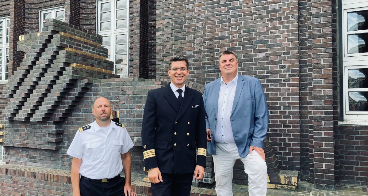 Zur Präsentation der Woche der Militärmusik stehen die Organisatoren vor dem Rathaus Wilhelmshaven