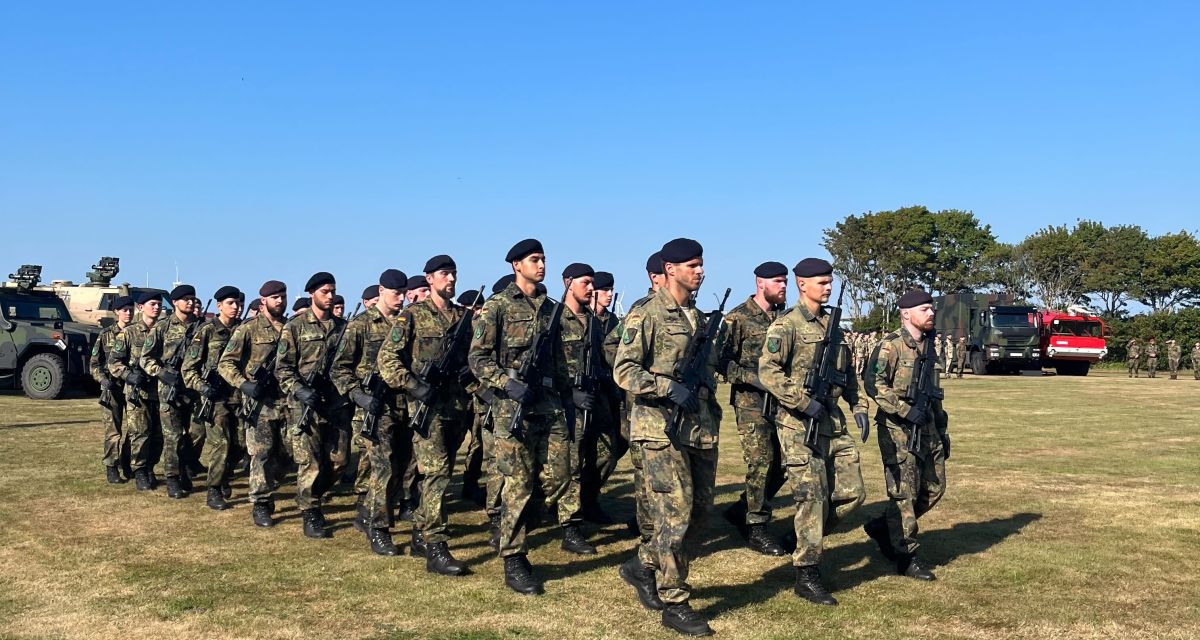 Im Rahmen der Kontingentverabschiedung Objektschutzregiment Luftwaffe Upjever marschieren viele Einsatzkräfte über eine Wiese