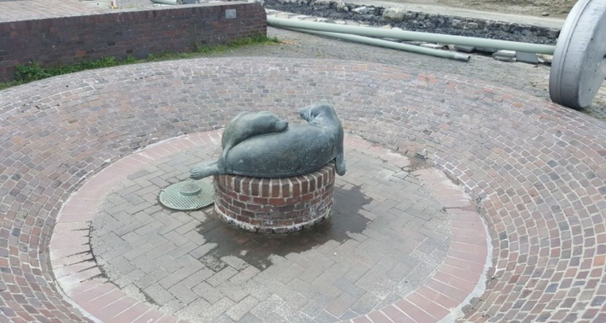 Zwei Bronze-Seehunde liegen in einem Brunnen. Der alte Brunnen des Bismarckplatzes Wilhelmshaven