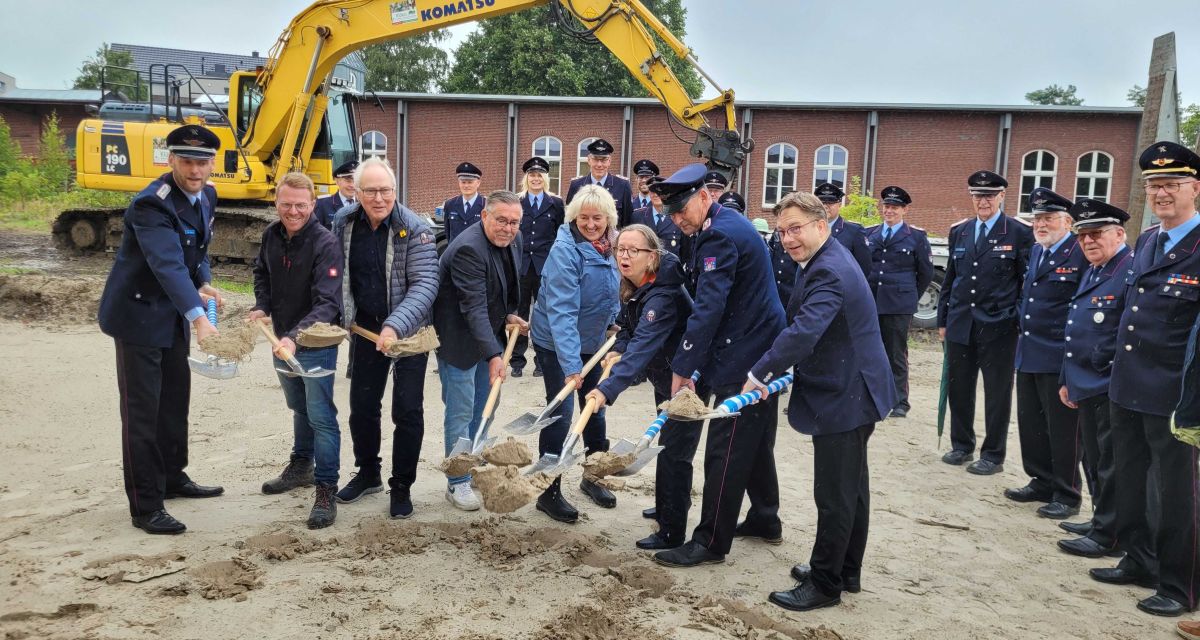 Zu sehen sind Mitglieder der Feuerwehr und Vertreter*innen der Stadt Jever beim offiziellen ersten Spatenstich für den Umbau der Feuerwache.