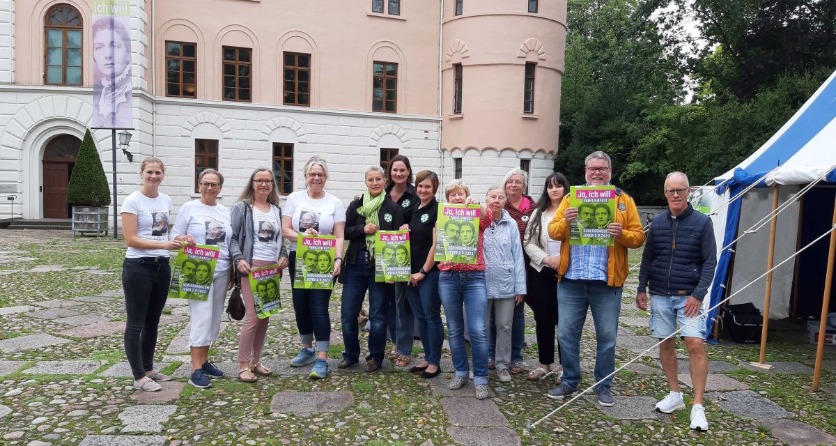 Die Organisator*innen des Familienfestes im Schlossmuseum Jever stehen auf dem Schlossplatz