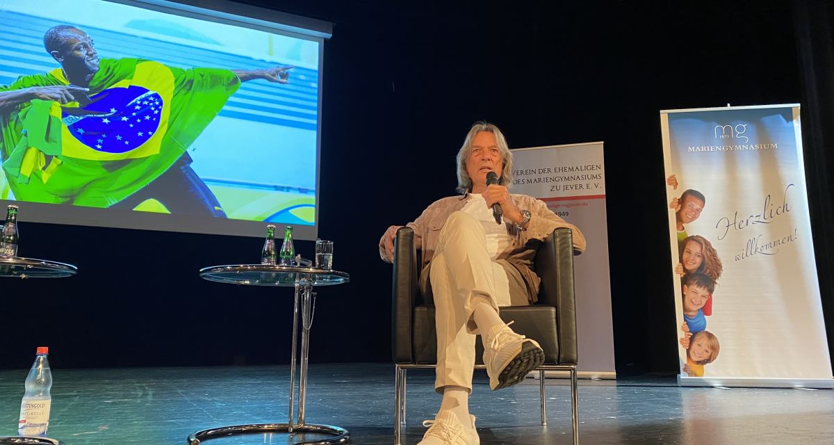 Hans-Wilhelm Müller-Wohlfahrt sitzt auf einer Bühne beim Festakt zum Geburtstag des Mariengymnasiums