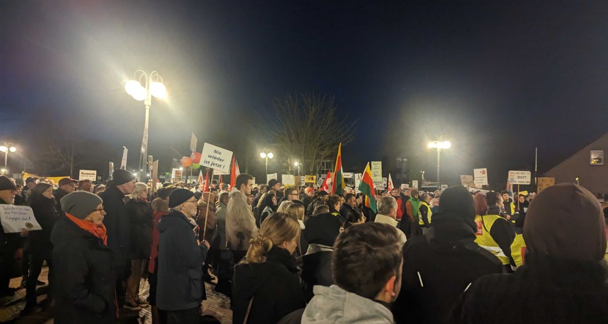 Zu sehen sind Gegendemonstrant*innen auf dem Vorplatz des Schortenser Bürgerhauses. Sie demonstrieren gegen einen 