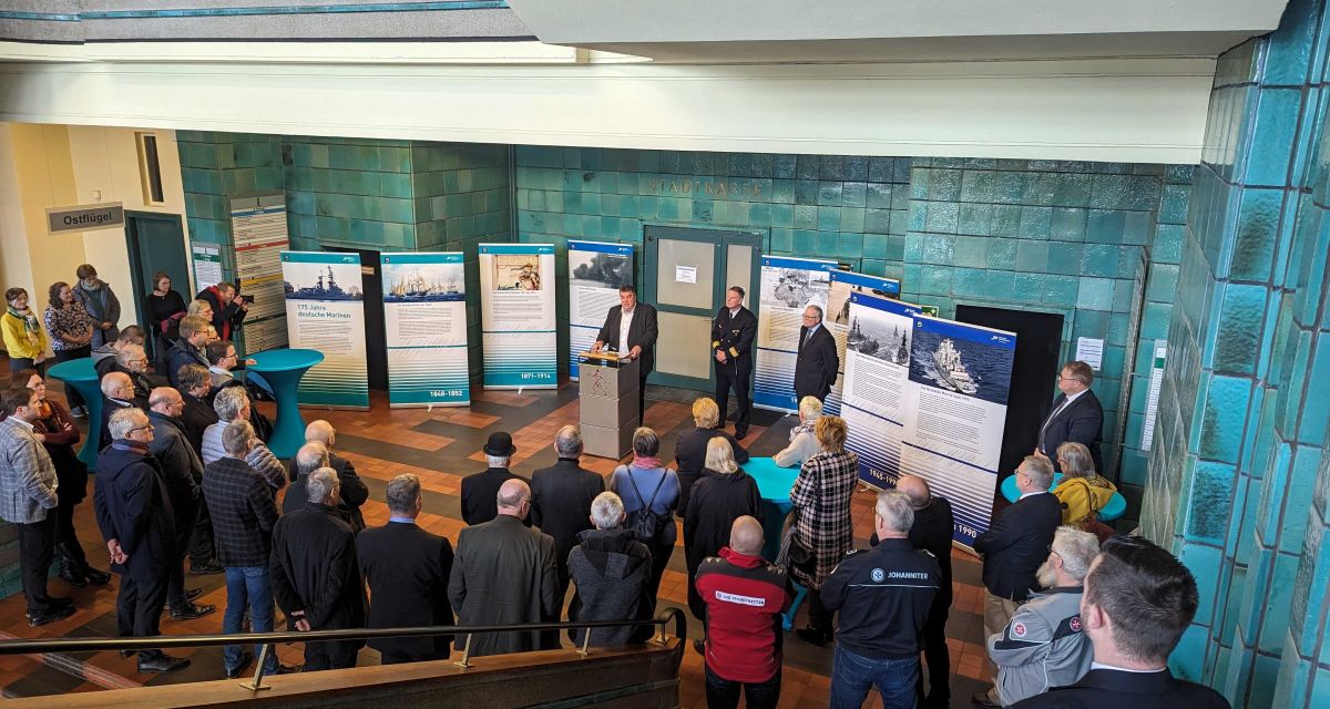 Menschen stehen im Foyer des Wilhelmshavener Rathauses zur Eröffnung der Sonderausstellung 174 Jahre Marinen