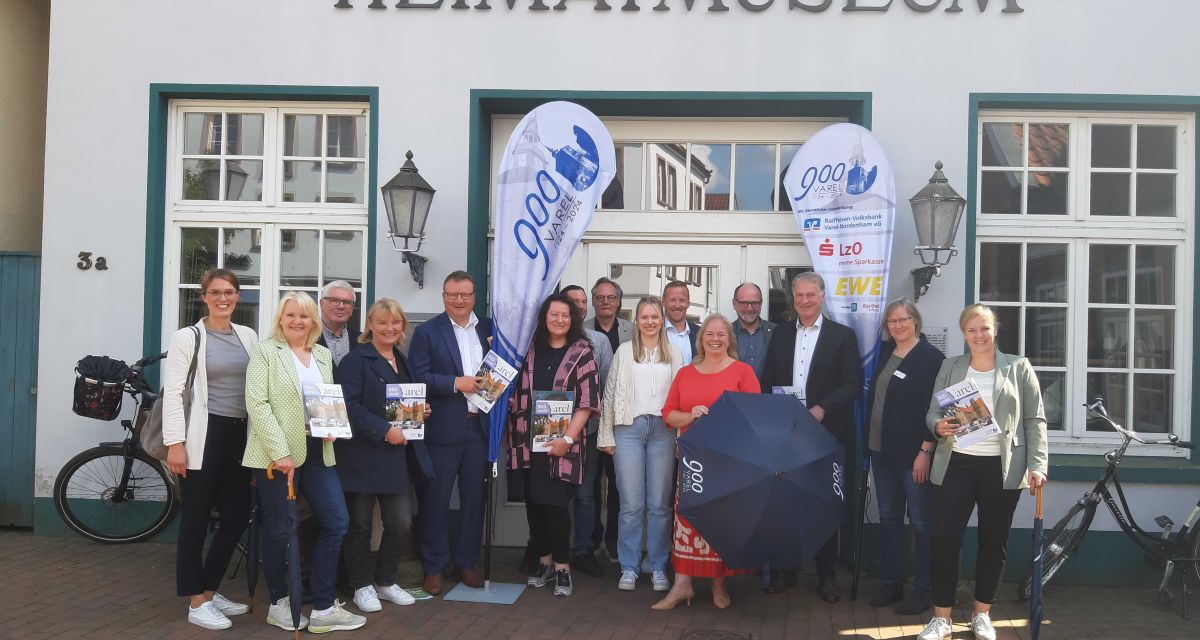 Menschen stehen bei der Veranstaltungen, Projekte und Aktionen zum 900 Jahres Jubiläum der Stadt Varel vor dem Heimatmuseum.