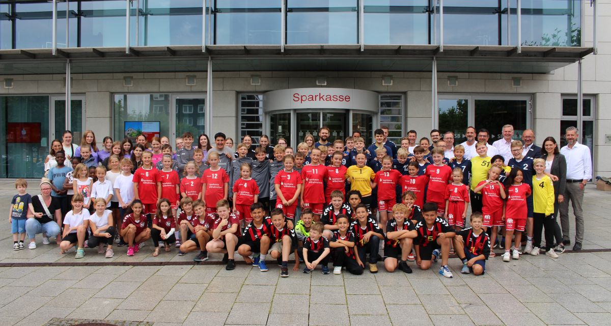 mehere Sportmannschaften vor Gebäude