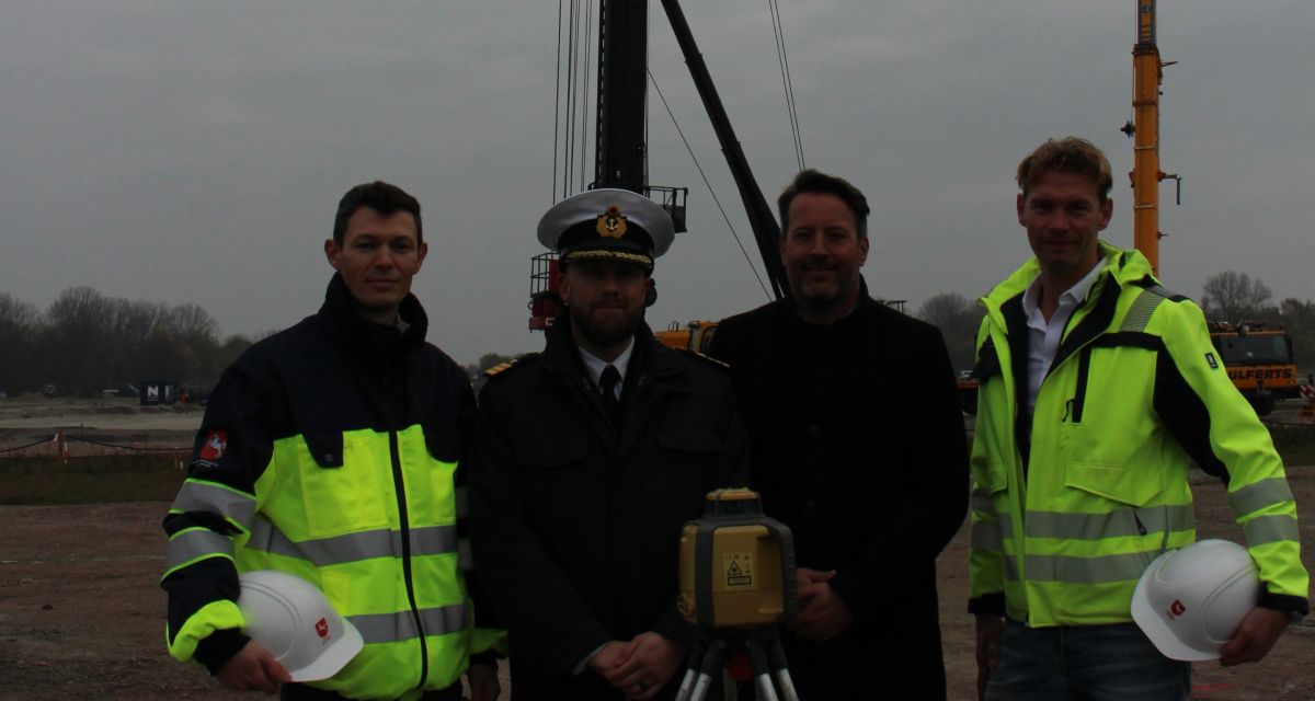 Auf dem Foto stehen vier Männer bei einem Messgerät vor einer Baustelle. Von links: Juri Reingard (Projektleiter), Korvettenkapitän Robert Falkner (Kasernenkommandant), Sönke Gebken (Baudirektor vom Staatlichen Baumanagement), Alexander Größ (Baugruppenleiter)