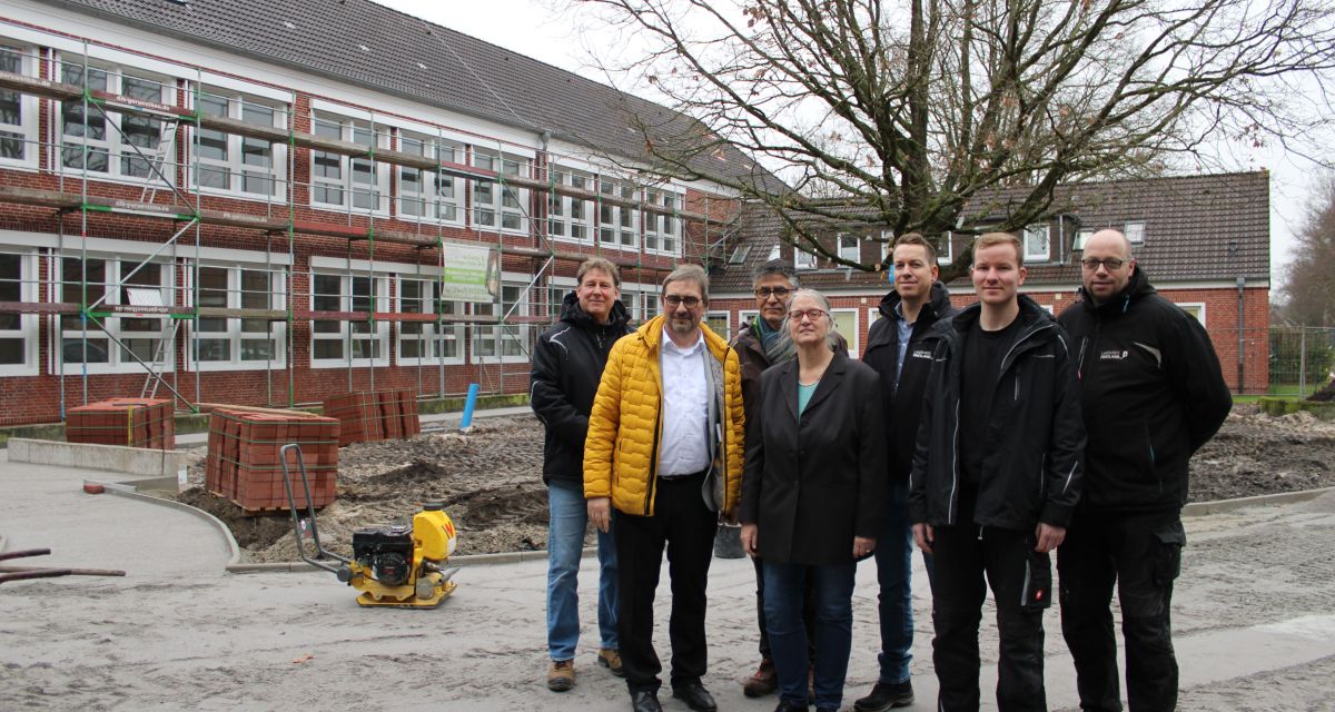 Ein Gruppenbild der Beteiligten zur Sanierung der Elisa-Kauffeld-Oberschule in Jever. Zu sehen sind hier (von links nach rechts): Steffen Schmid (Projektleitung „Barrierefreie Außenanlagen“), Landrat Sven Ambrosy, Ünal Alpaslan (Leiter des Fachbereichs Gebäudemanagement), Schulleiterin Berta Paasman, Björn Jürgensen (Projektleitung „Energetische Sanierung des Altbautraktes“), Joris Luiken und Jens Gromöller (beide Hausmeister).
