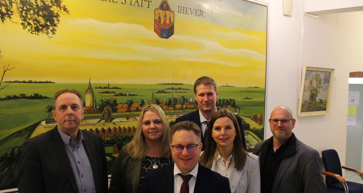 Vor dem historischen Stadtbild Jevers stehen die Abteilungsleiterinnen und -leiter.Von links: Manfred Meile, Inka Wüllner, Bürgermeister Jan Edo Albers (vorne), Tobias Masemann, Dana Ehlert und Mario Atzesdorfer