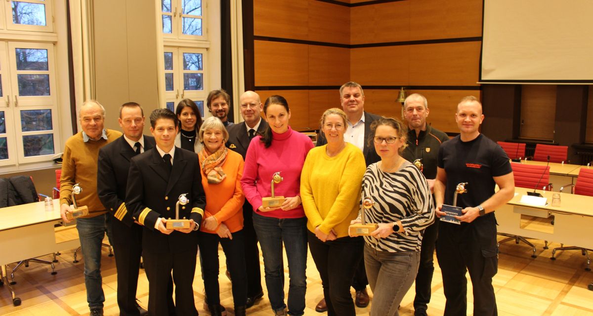 Im Ratsaal der Stadt Wilhelmshaven steht eine Menschengruppe. Ein Teil hält eine Skultptur als Auszeichnung im rahmen des stadtradelns in der Hand