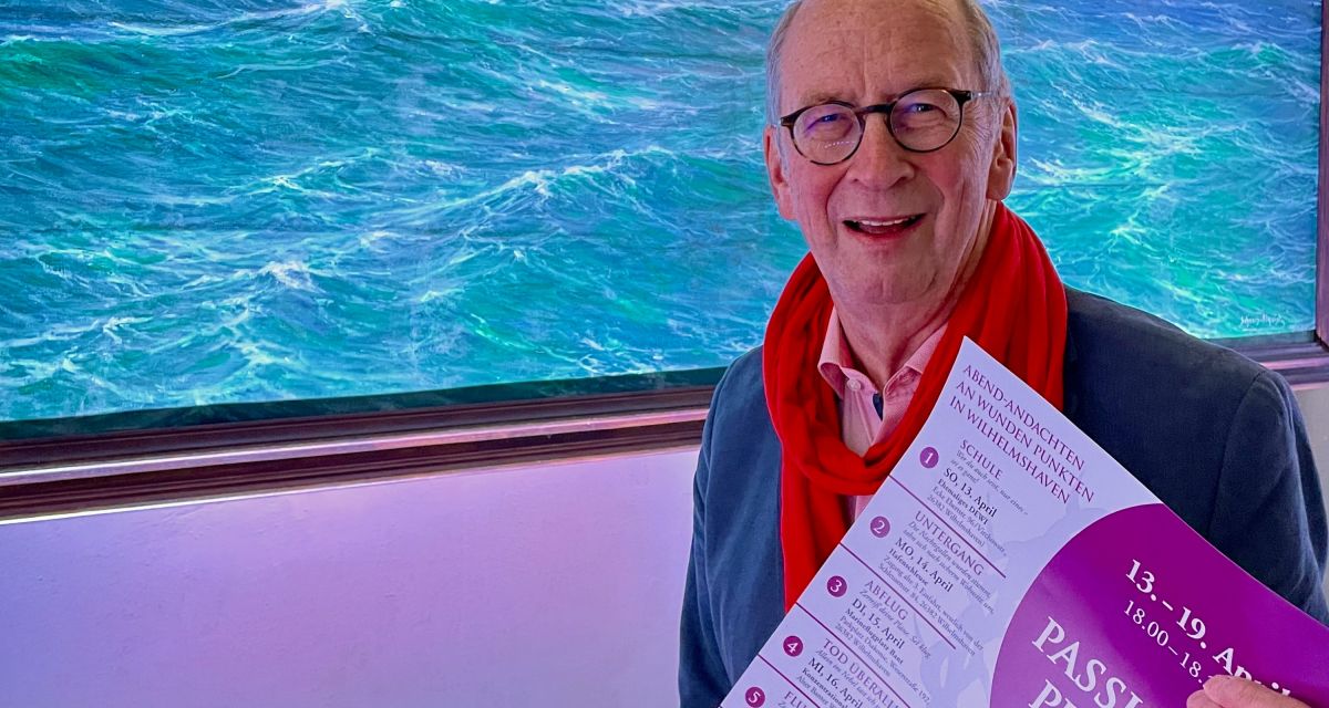 Pastor Frank Morgenstern mit Flyer vor Altarbild