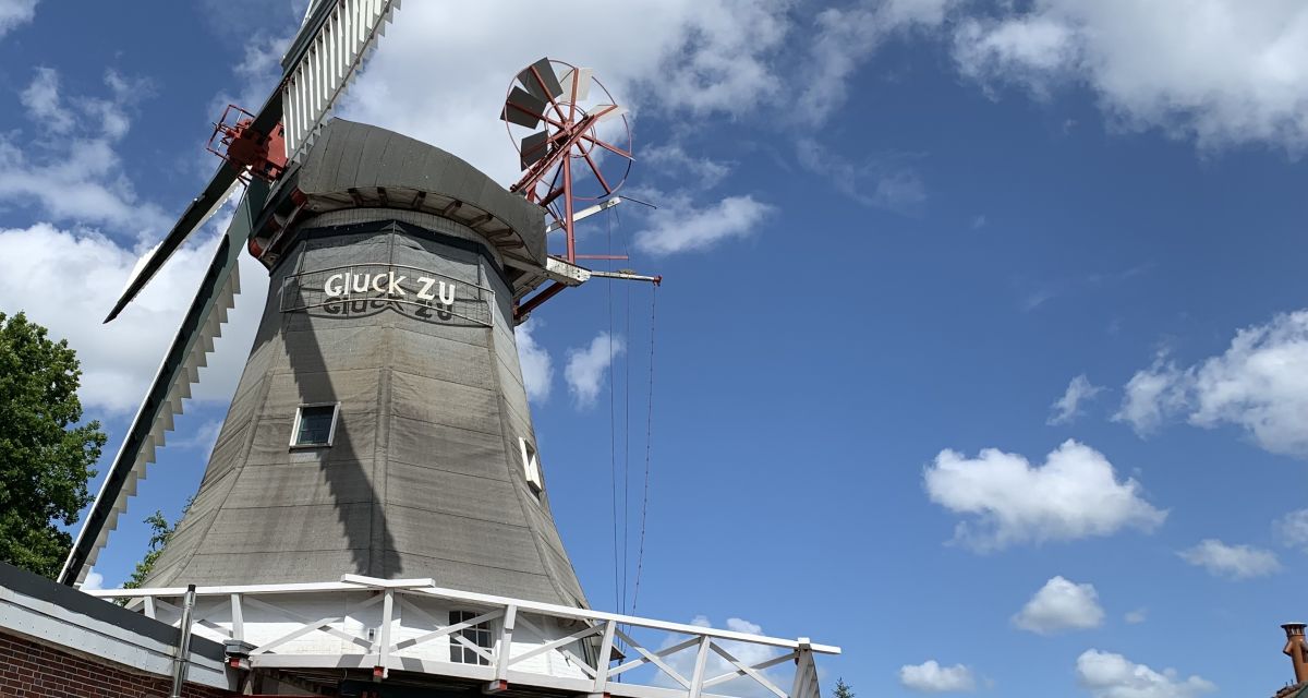 Zu sehen ist die alte Peldemühle in Wittmund bei einem leicht bewölkten Himmel.