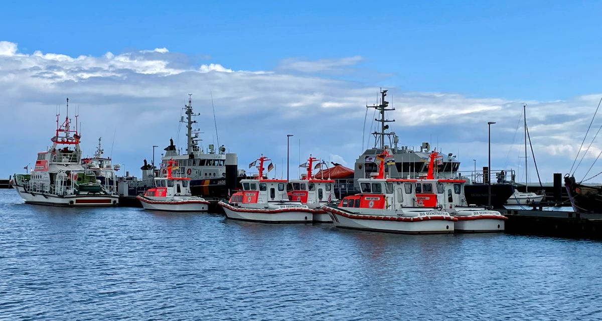 Zu sehen sind mehrere Seenotrettungsboote im Wilhelmshavener Nassauhafen bei teils bewölktem Himmel