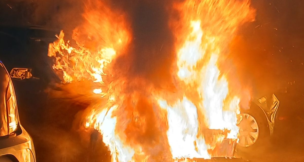 Zu sehen ist ein brennendes Fahrzeug.