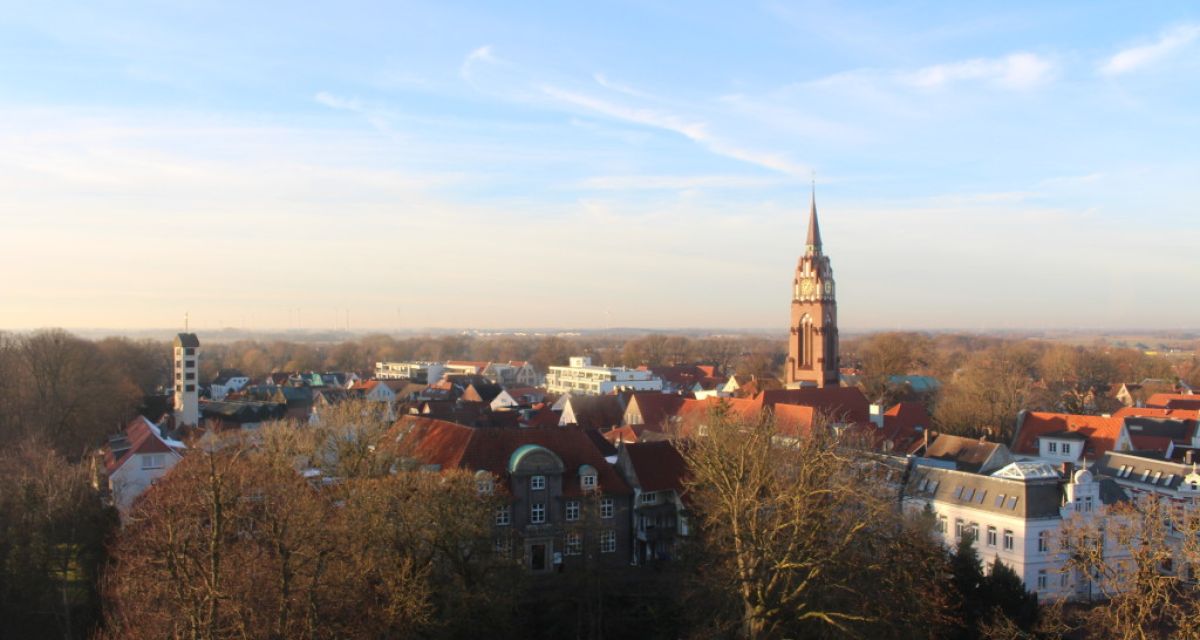 Eine Ansicht der Stadt Jever an einem sonnigen Tag vom Schlossturm aus fotografiert. Zu sehen ist unter anderem der Turm Stadtkirche und das alte Gebäude der LzO.