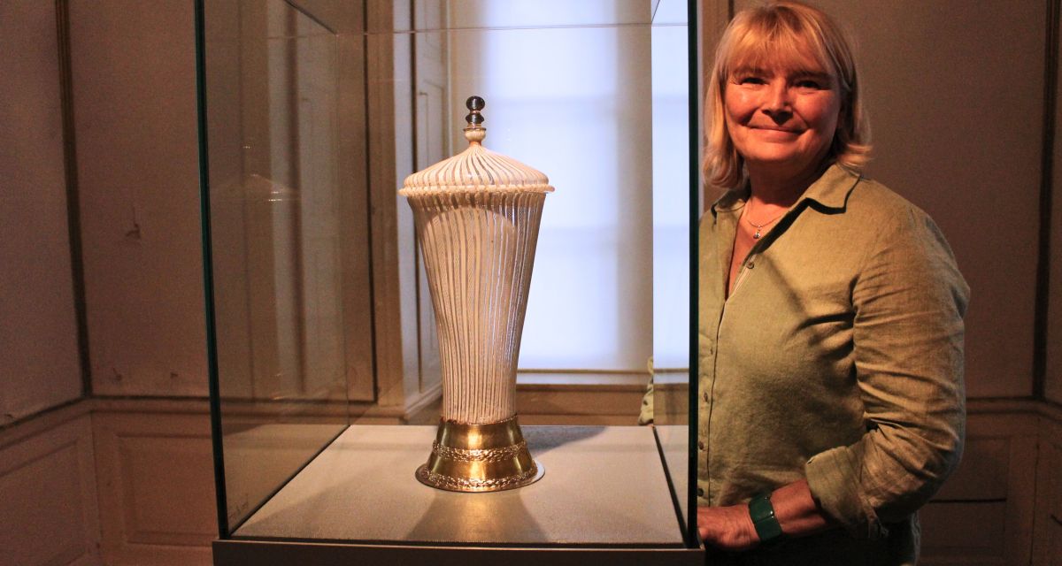 Antje Sande, die Leiterin des Schlossmuseums in Jever, posiert mit dem Fadenglas Pokal von maria von Jever 