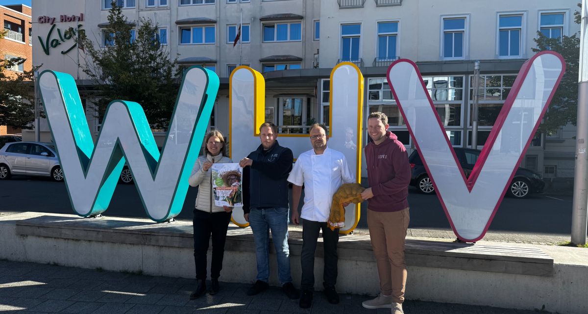 Zu sehen sind vier Personen vor den Buchstaben WHV