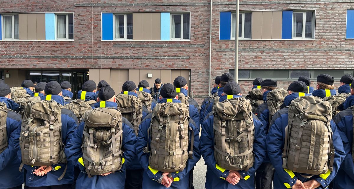 Zu sehen sind Marinesoldaten beim Antreten in Rückansicht.
