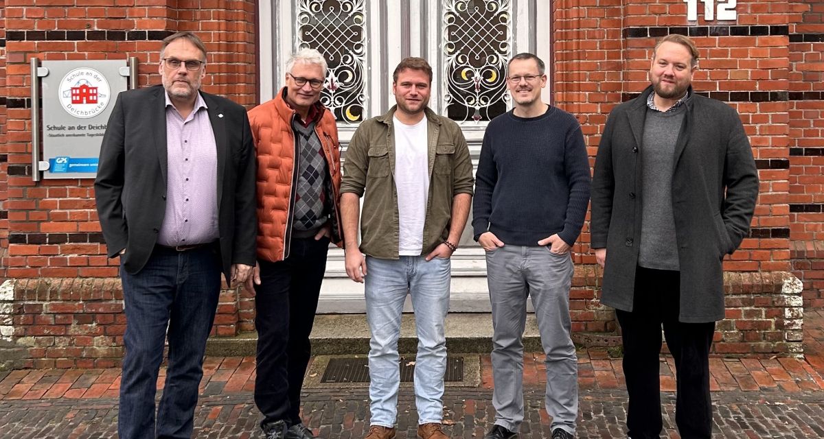 Vor der Schule an der Deichbrücke stehen fünf Männer: Klaus Puschmann, Klaas Ohnesorge, Thore Opitz;Erich Fürchtenicht; Nils Gastmann