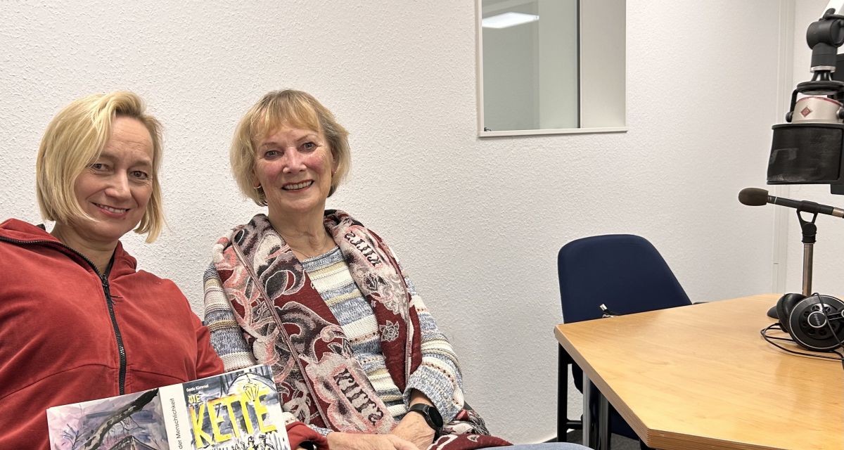 Zwei Frauen mit Buch, sitzend im Studio