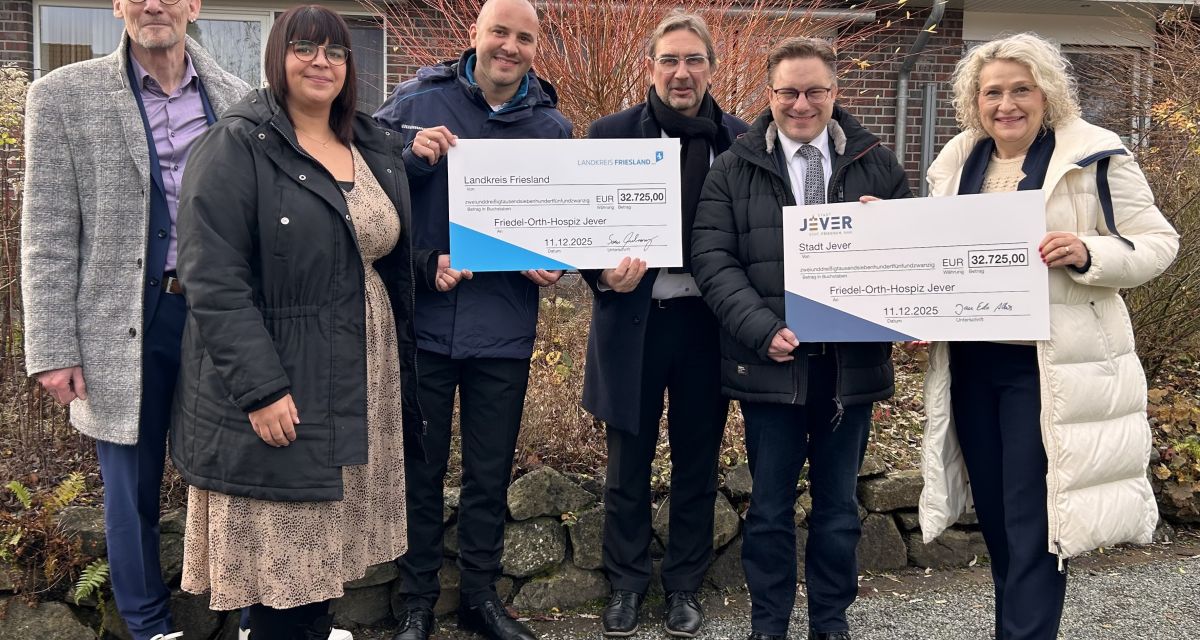 Zu sehen ist die Übergabe symbolischer Schecks an das friedel Orth-Hospiz durch Landrat Sven Ambrosy und Bürgermeister Jan Edo Albers an Träger und Mitarbeitende des Hospizes in Jever