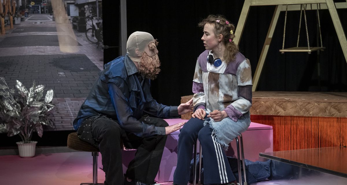 Zwei Charaktere sitzen sich auf der Bühne gegenüber