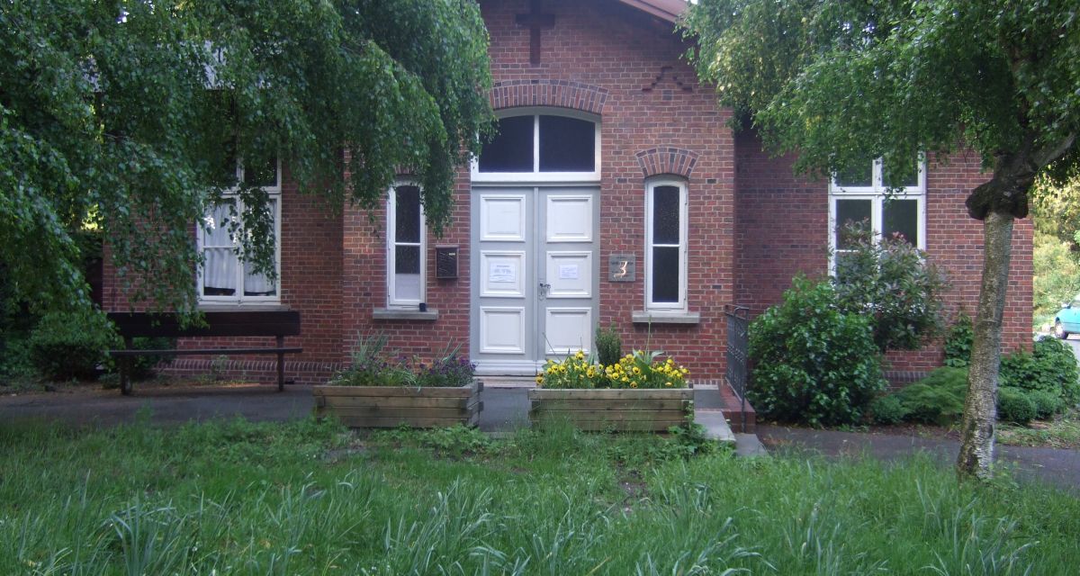 Zu sehen ist die Frontansicht eines Backsteingebäudes der heil- und Pflegeanstalt Wehnen, wo in der NS-zeit Patient:innen ermordet wurden.