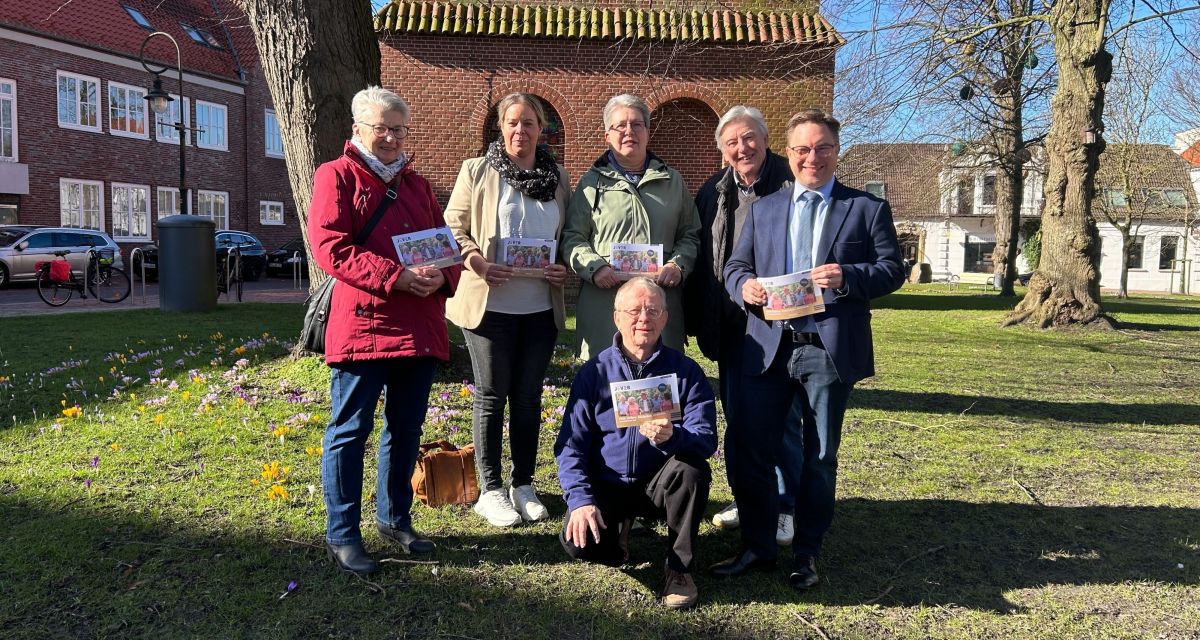Vor der Turm der Schlosskirche iin jever stehen Rita Clasen, Julia Meyer, Ingrid Schmidt, Thomas Schitzler, Jan Edo Albers, in der Mitte Konrad Lappe Flyer halten in der Sonne